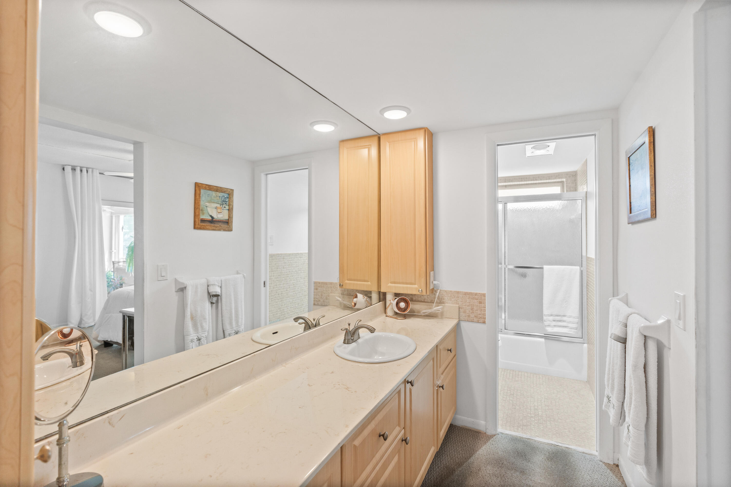 25 Southeast 13th Street, Unit B3 Boca Raton, FL 33432 - Photo 17 of 26 a bathroom with a double vanity sink a mirror and a bathtub