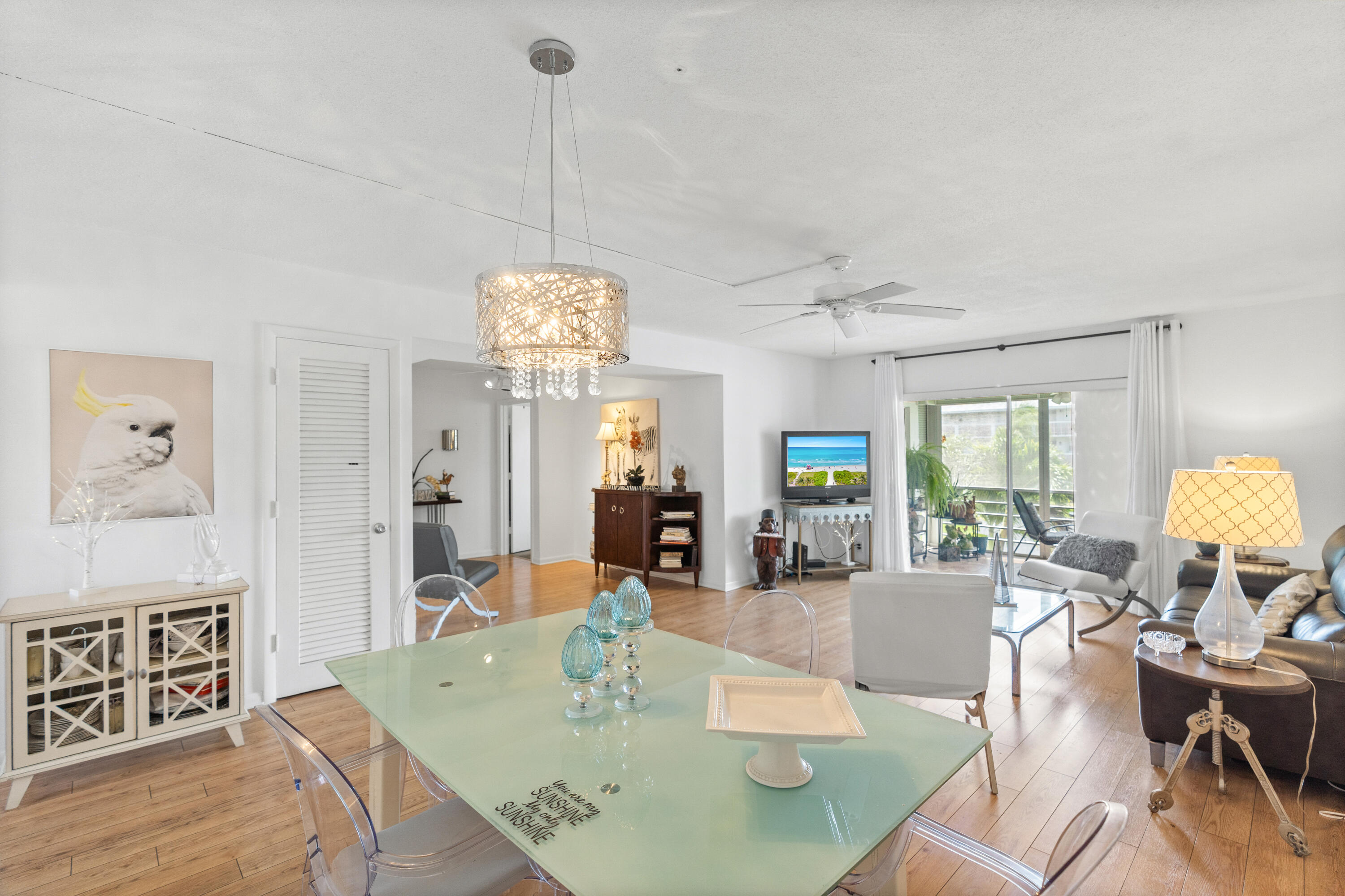 25 Southeast 13th Street, Unit B3 Boca Raton, FL 33432 - Photo 2 of 26 a view of a dining room with furniture wooden floor and chandelier