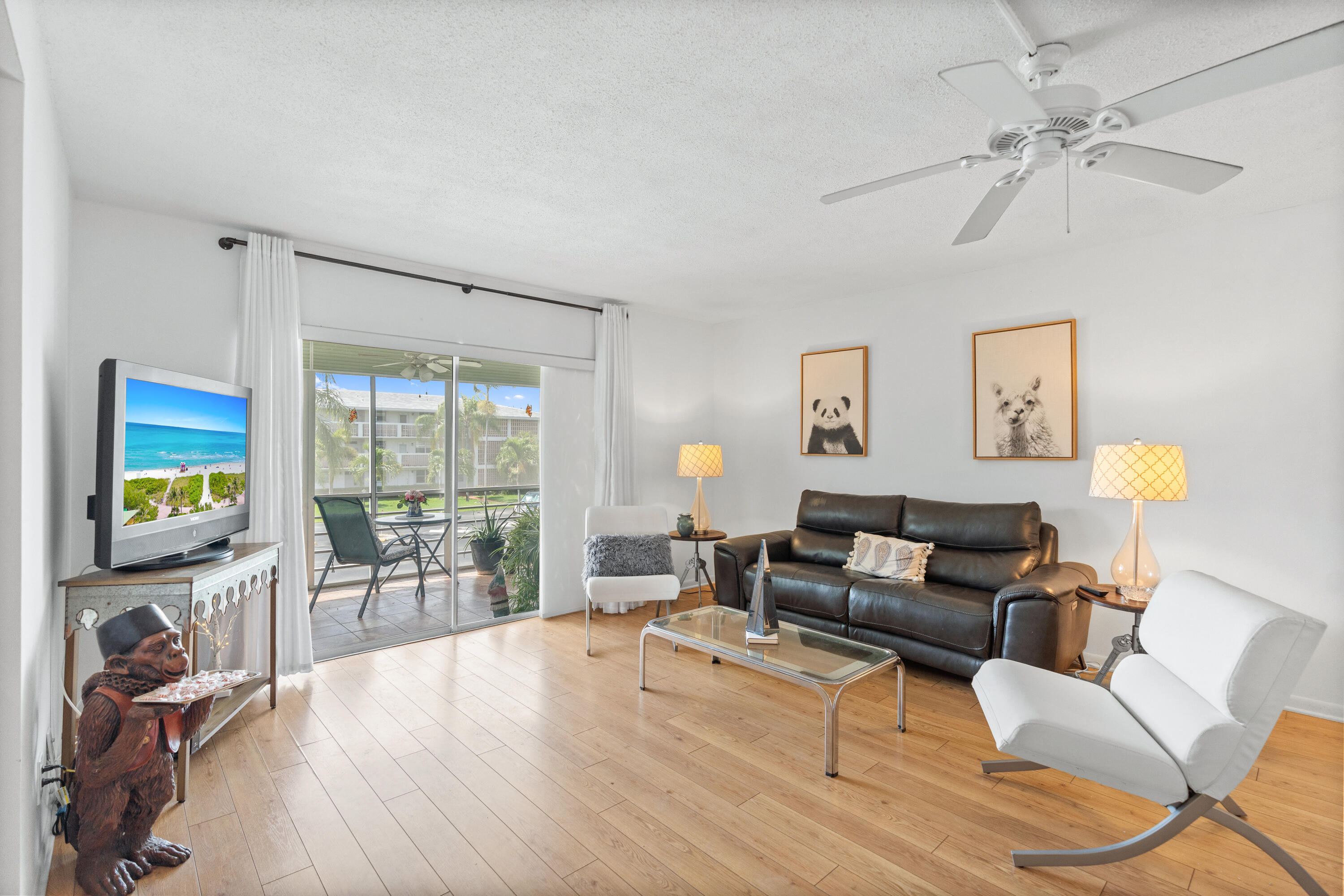 25 Southeast 13th Street, Unit B3 Boca Raton, FL 33432 - Photo 6 of 26 a living room with furniture a floor to ceiling window and a flat screen tv