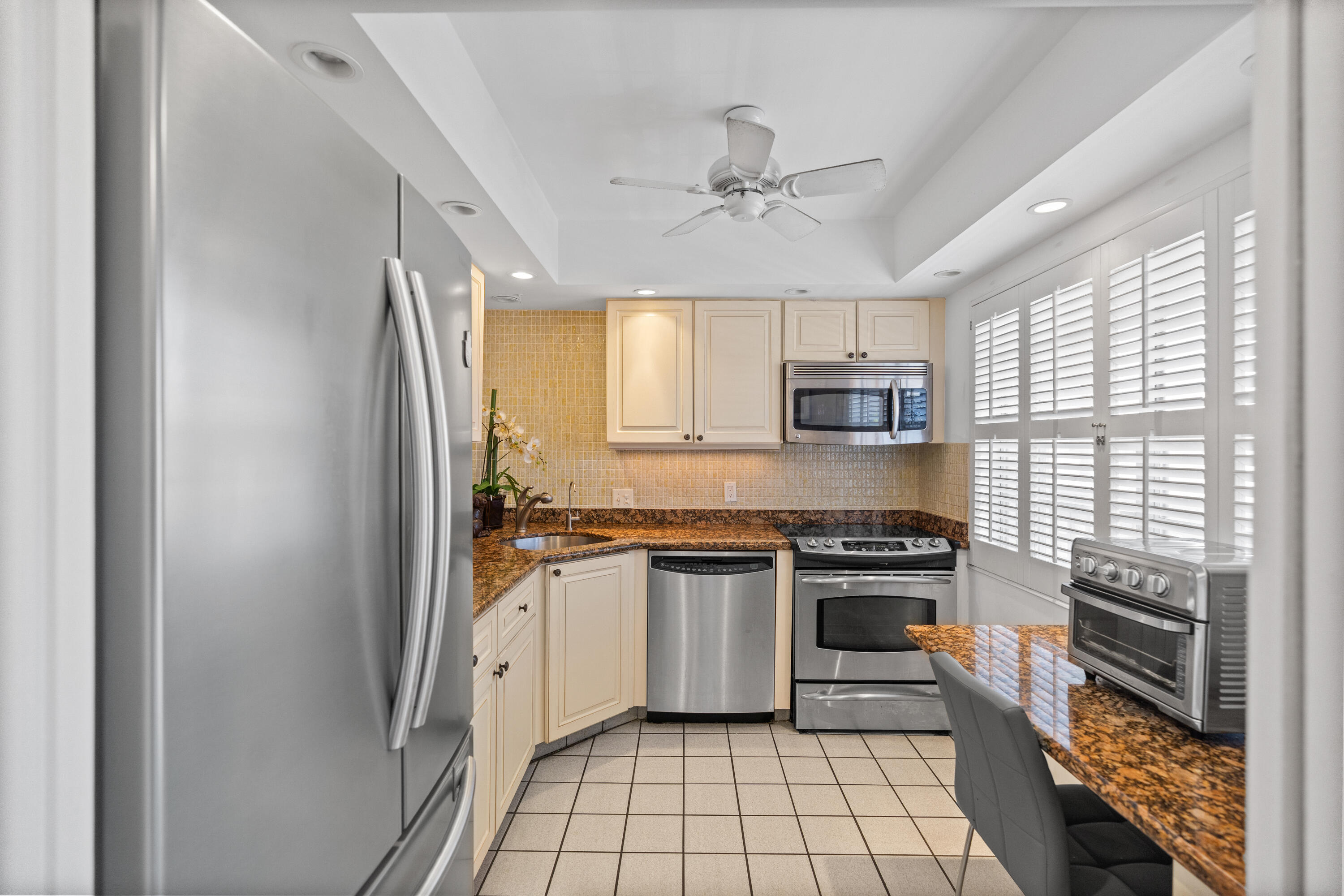 25 Southeast 13th Street, Unit B3 Boca Raton, FL 33432 - Photo 9 of 26 a kitchen with stainless steel appliances granite countertop a stove sink and refrigerator