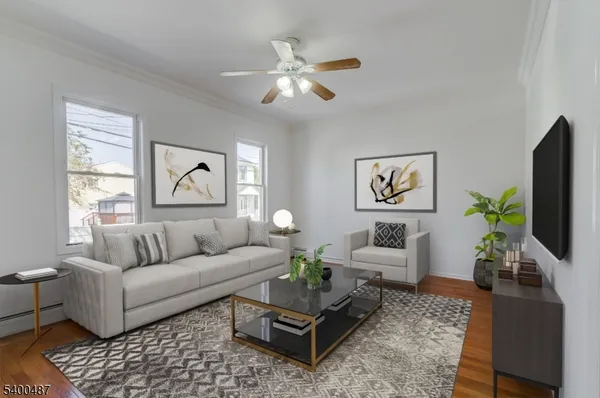 a living room with furniture a flat screen tv and a window