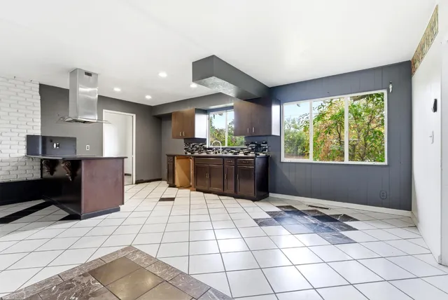 a kitchen with stainless steel appliances kitchen island granite countertop a refrigerator and a stove top oven