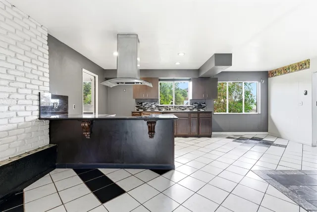 a view of kitchen with stainless steel appliances kitchen island granite countertop a refrigerator a sink and a stove