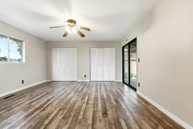a view of empty room with wooden floor