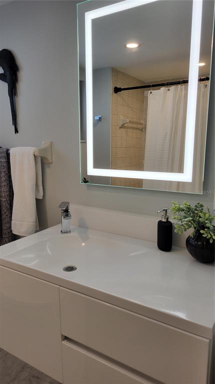 11 Sunset Drive, Unit 704 Sarasota, FL 34236 - Photo 20 of 34 a bathroom with a sink and mirror