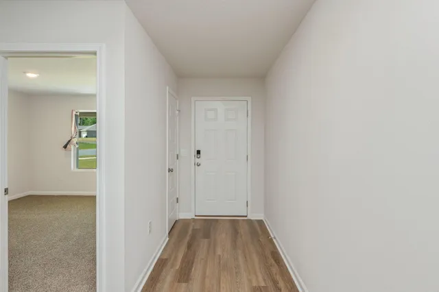 a view of a room with wooden floor and a bathroom