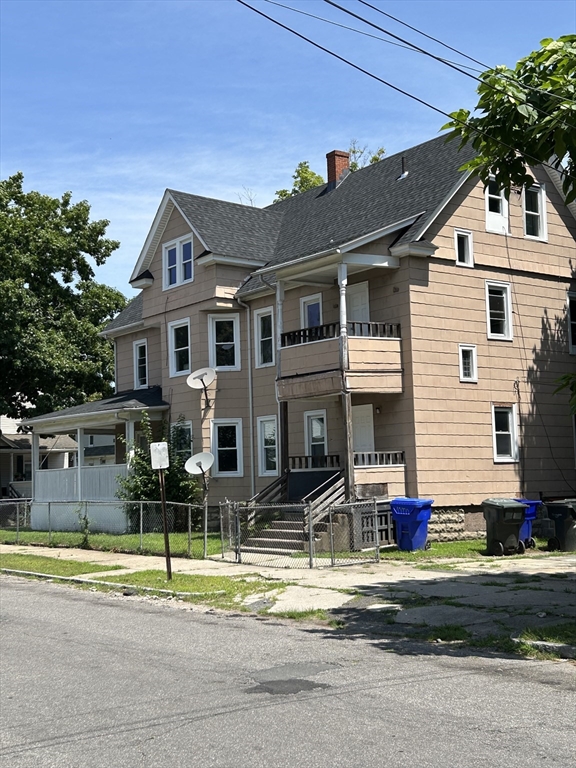 385 Orange Street Springfield, MA 01108 - Photo 3 of 11 a view of a white house with a swimming pool and lawn chairs under an umbrella