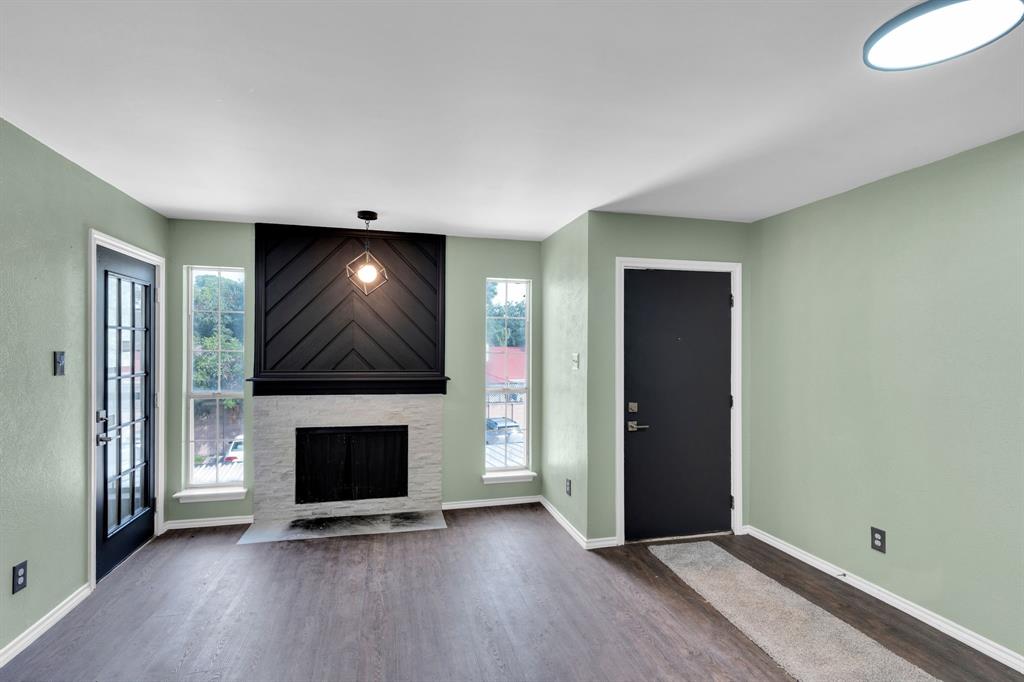 3206 South Fielder Road, Unit 209 Arlington, TX 76015 - Photo 5 of 22 an empty room with wooden floor fireplace and windows