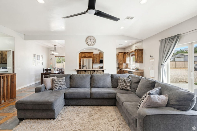 7776 Wagon Road East St. George, UT 84770 - Photo 11 of 76 Living area featuring ceiling fan, stone tile flooring, recessed lighting, and vaulted ceiling