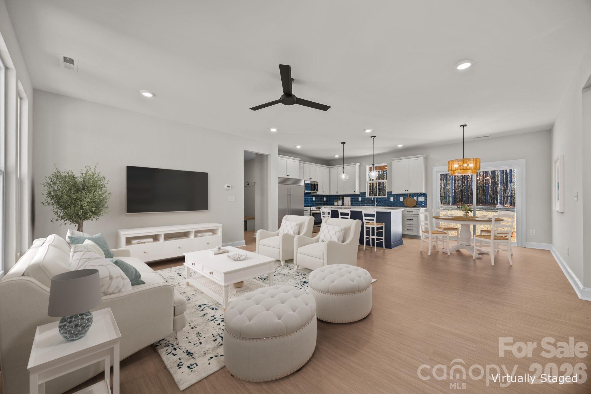 a living room with furniture kitchen view and a flat screen tv