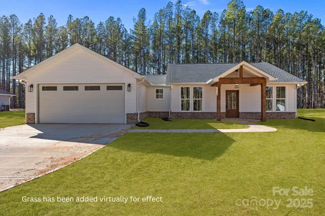 a front view of a house with a yard and trees