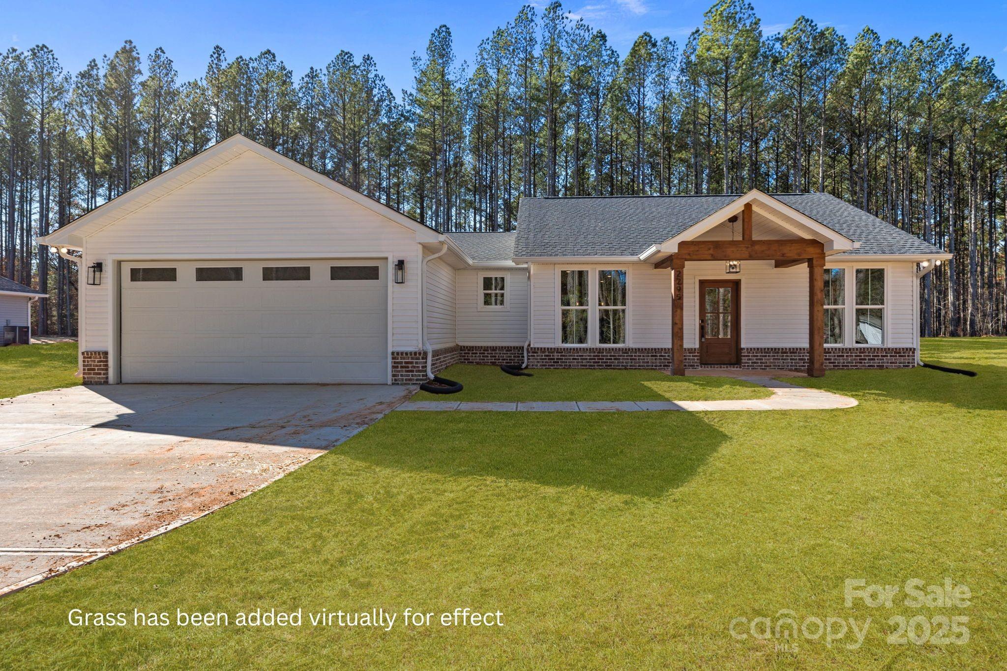 a front view of a house with a yard and trees