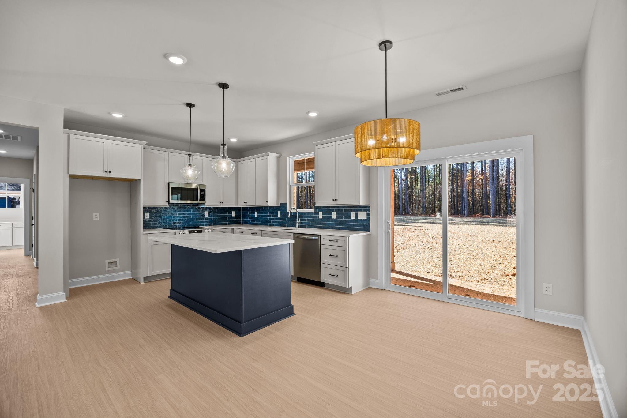 2295 Lee Lawing Road Lincolnton, NC 28092 - Photo 14 of 46 a large kitchen with a refrigerator a stove a oven and a chandelier