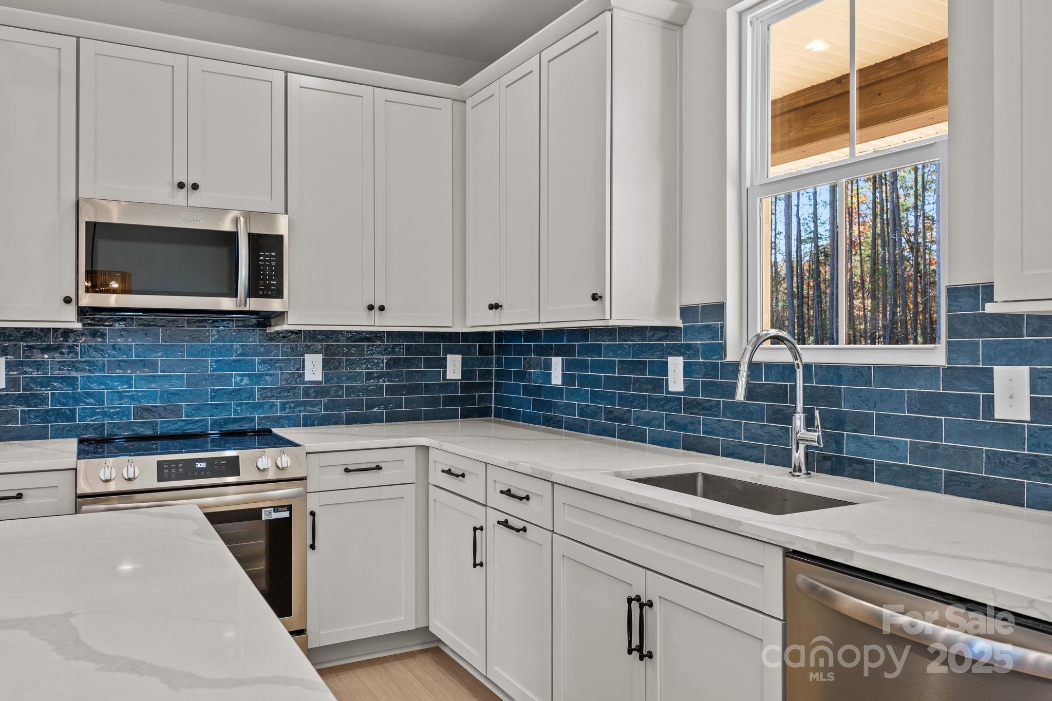 2295 Lee Lawing Road Lincolnton, NC 28092 - Photo 19 of 46 a kitchen with white cabinets and a stove top oven