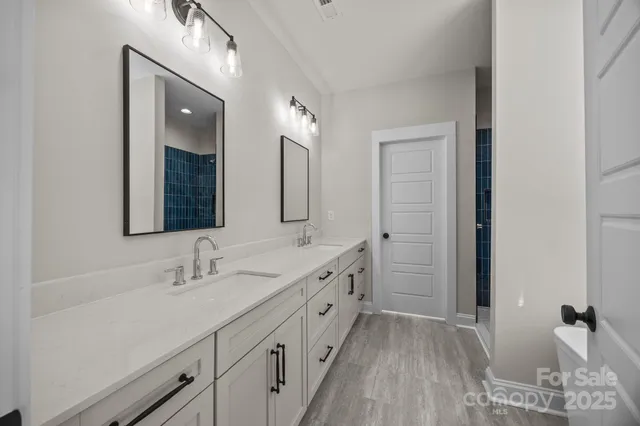 a spacious bathroom with double vanity and mirrors