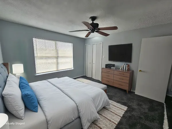 a bedroom with a bed and a flat screen tv