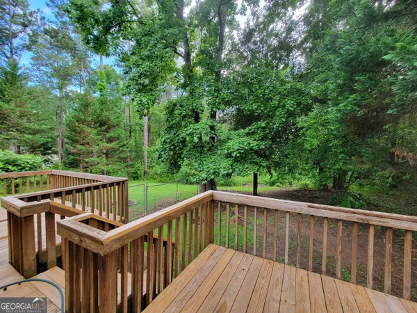 a balcony with wooden floor and yard in the back