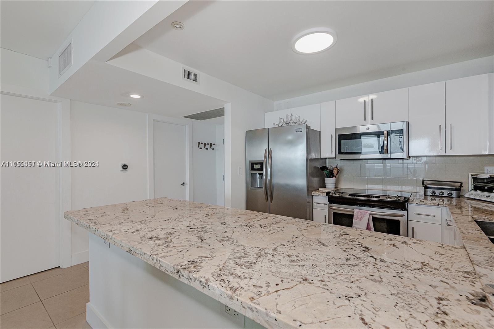 2301 Collins Avenue, Unit 938 Miami Beach, FL 33139 - Photo 17 of 47 a kitchen with stainless steel appliances granite countertop a sink stove and refrigerator