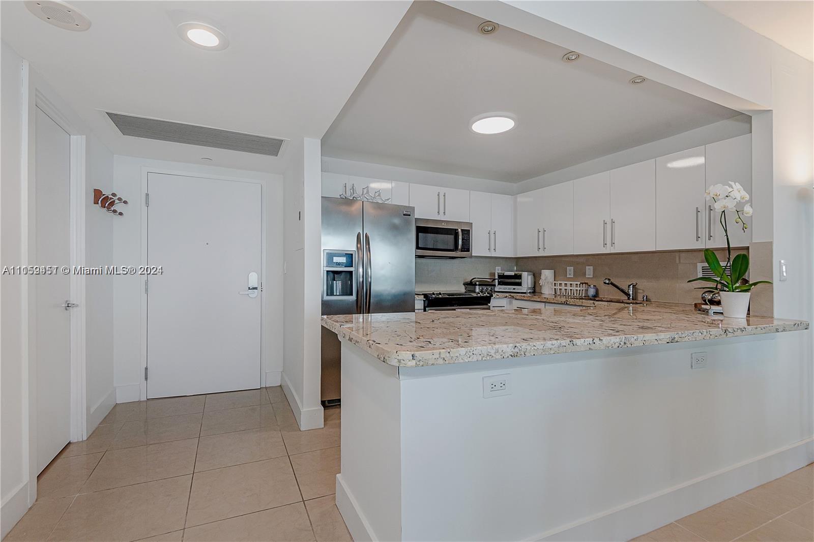 2301 Collins Avenue, Unit 938 Miami Beach, FL 33139 - Photo 18 of 47 a view of a kitchen with a sink a counter top space and stainless steel appliances