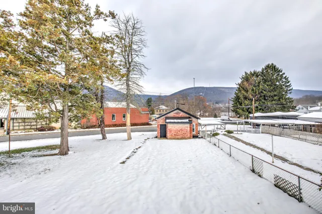 a view of a yard with wooden fence