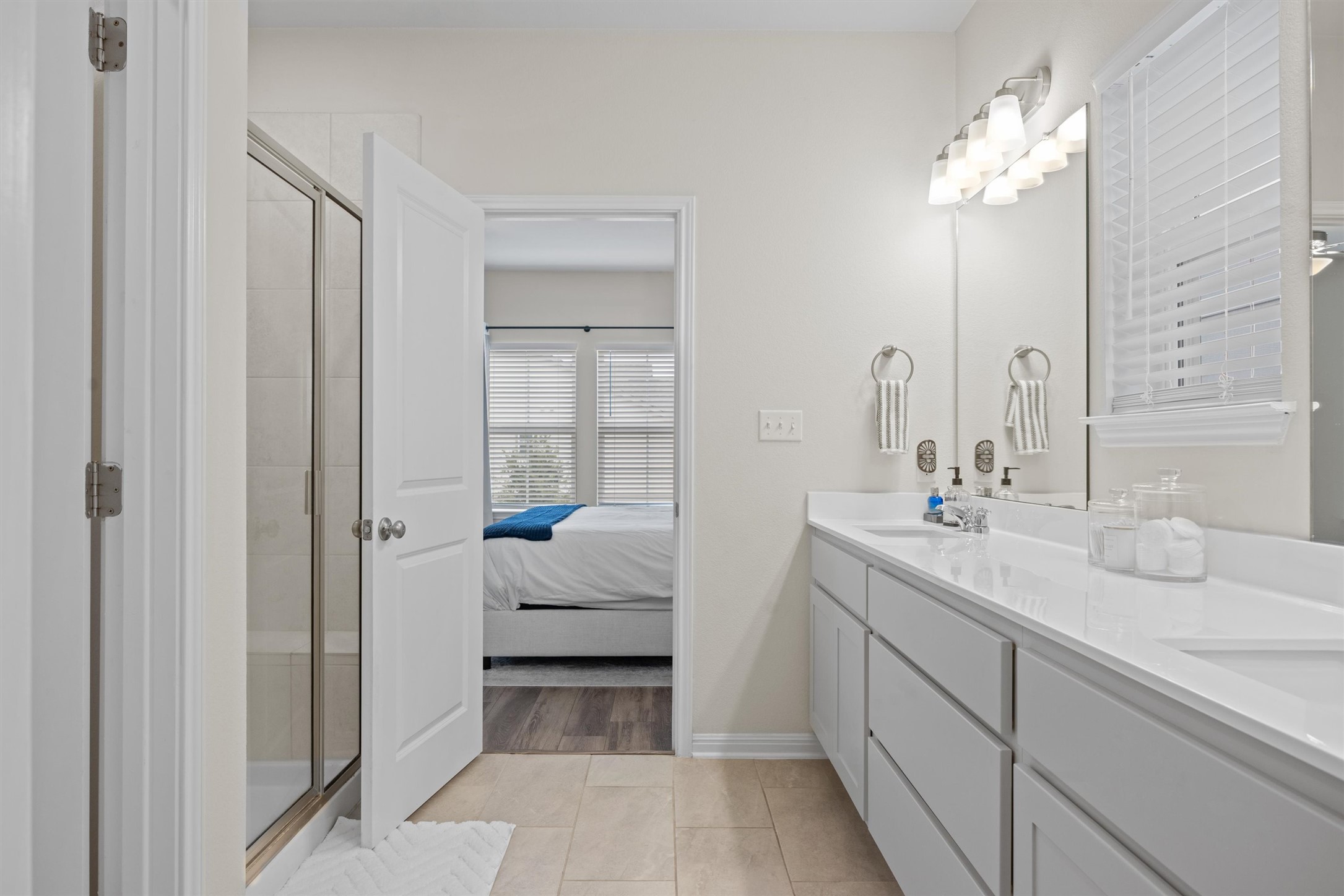 313 Toddy Way Leander, TX 78641 - Photo 21 of 39 Ensuite bathroom featuring a stall shower, double vanity, and light tile patterned floors