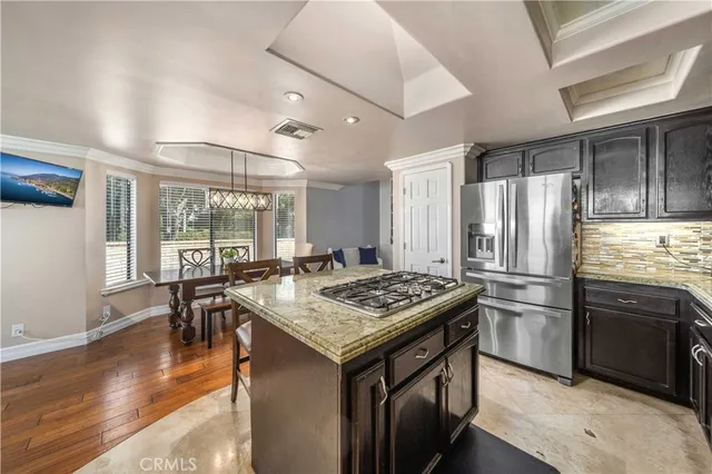 a kitchen that has a stove a table and chairs in it