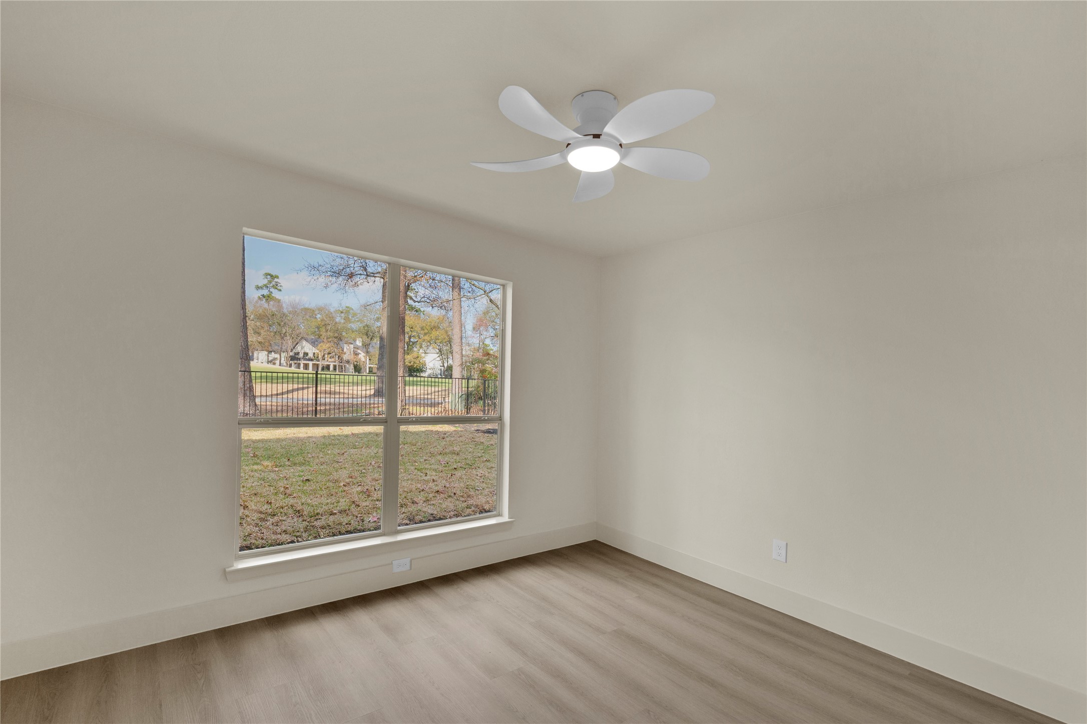 20 Buttonbush Court The Woodlands, TX 77380 - Photo 34 of 43 an empty room with wooden floor fan and windows