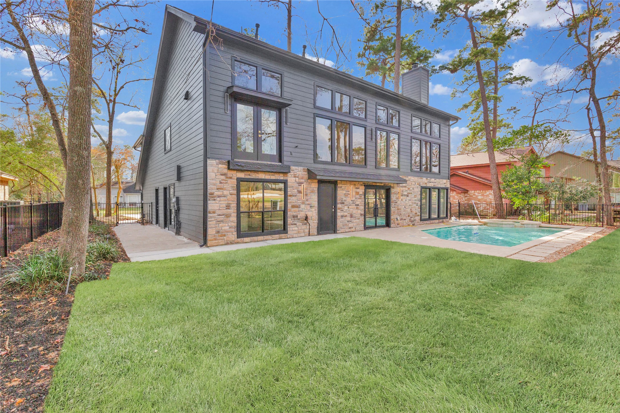 20 Buttonbush Court The Woodlands, TX 77380 - Photo 38 of 43 a view of a brick house with a yard