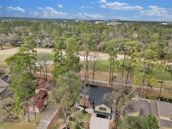an aerial view of a house with yard and swimming pool
