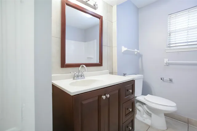 a bathroom with a granite countertop sink a toilet and a mirror