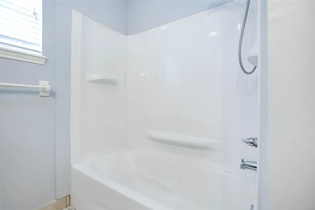 a bathroom with a bath tub with a shower