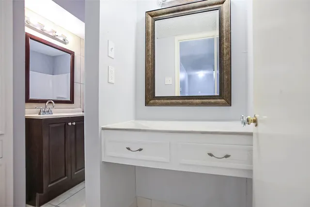 a bathroom with a sink vanity and mirror