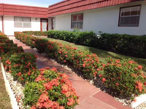 a front view of a house with a yard and flowers