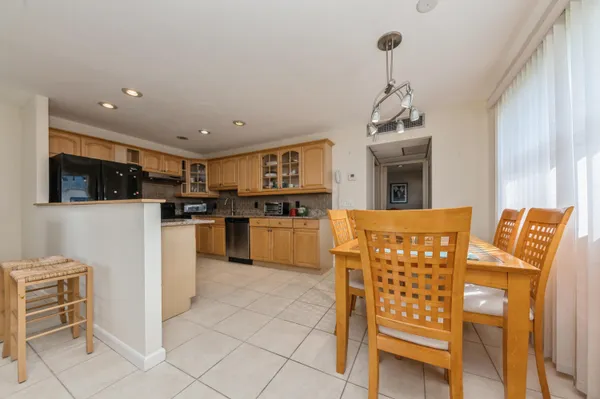 a kitchen with stainless steel appliances kitchen island granite countertop a refrigerator and microwave