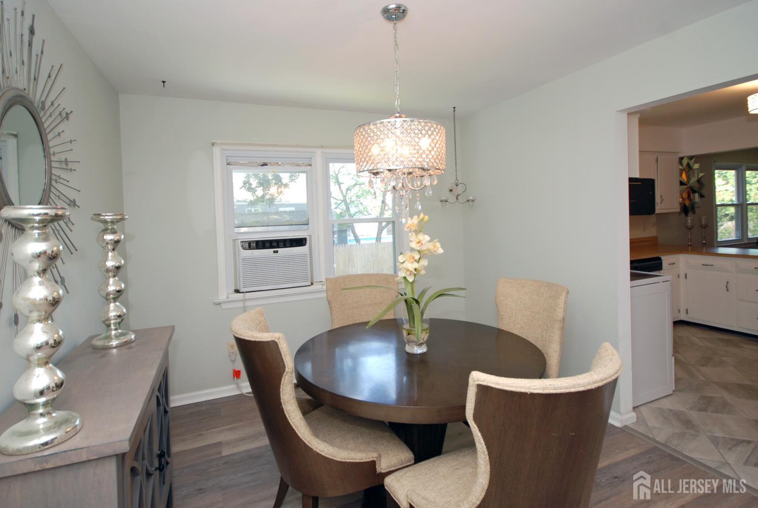 4 Kalman Court Middlesex, NJ 08846 - Photo 13 of 30 a dining room with wooden floor a chandelier a wooden table and chairs