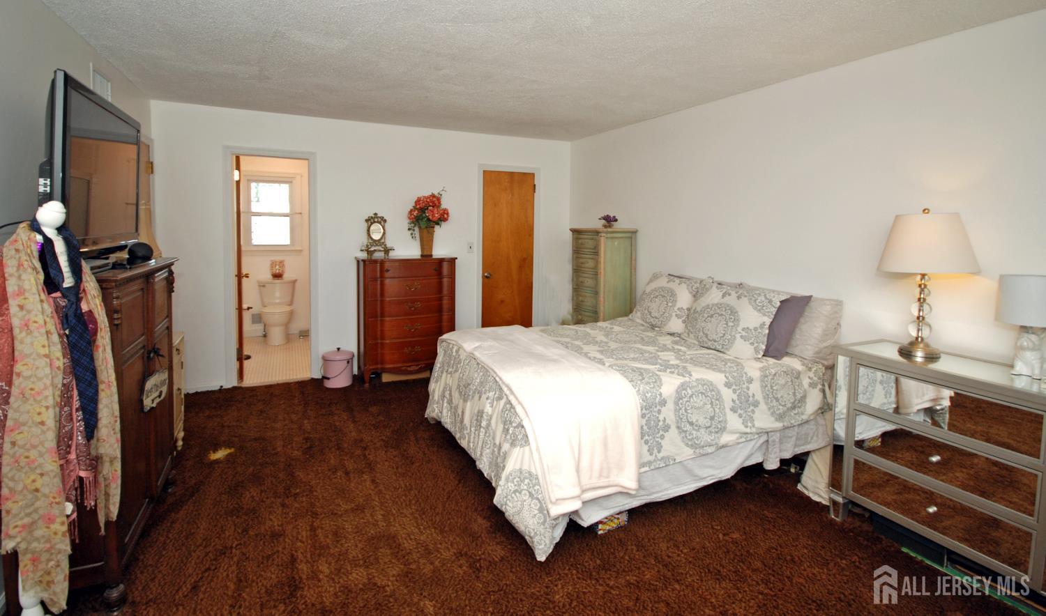 4 Kalman Court Middlesex, NJ 08846 - Photo 19 of 30 a bedroom with a bed and a flat tv screen on the dresser