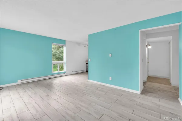 a view of a room with wooden floor and a fireplace