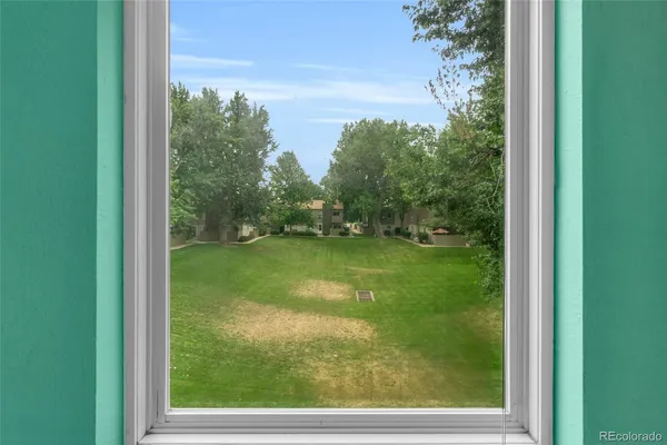 a view of green field with trees in the background