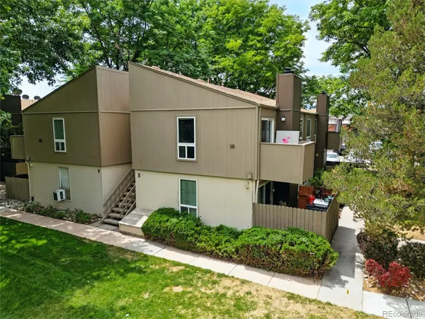 an aerial view of residential houses with outdoor space and trees