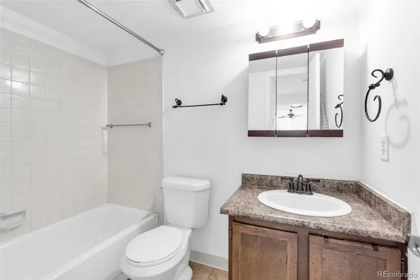 a bathroom with a granite countertop sink a toilet and a bathtub