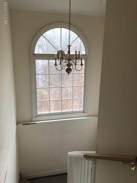 2300 Upper River Road Macon, GA 31211 - Photo 20 of 32 an empty room with wooden floor chandelier and a window