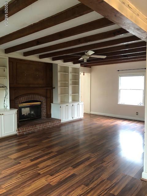 2300 Upper River Road Macon, GA 31211 - Photo 7 of 32 a view of an empty room with wooden floor fireplace and a window