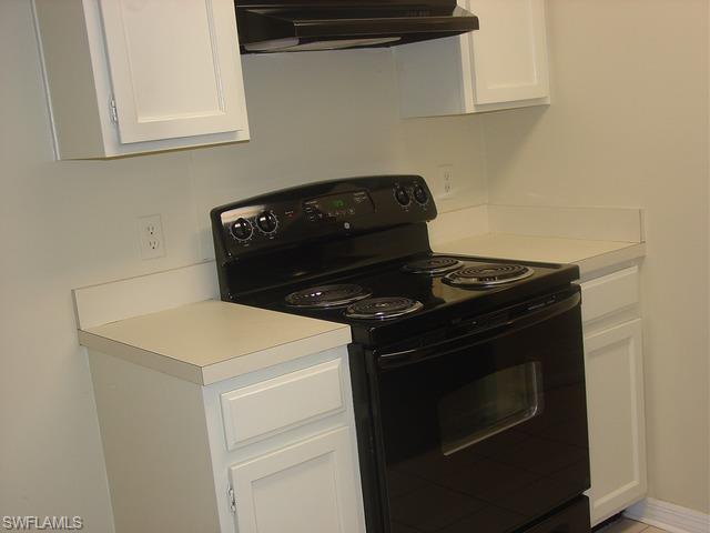 110 Cypress Way East, Unit F5 Naples, FL 34110 - Photo 10 of 11 a stove top oven sitting inside of a kitchen