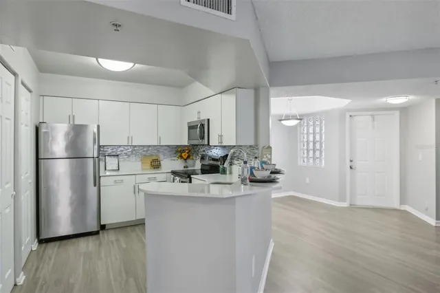 a kitchen with a refrigerator a sink and a stove top oven