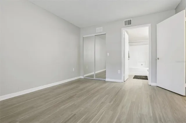 a view of an empty room with wooden floor