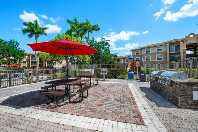 a view of a patio with a table and chairs under an umbrella