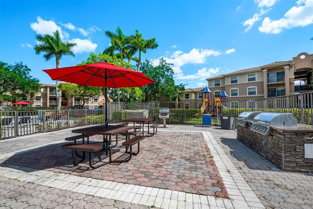 10101 Southwest 14th Street, Unit 2B9202 Pembroke Pines, FL 33025 - Photo 6 of 48 a view of a patio with a table and chairs under an umbrella