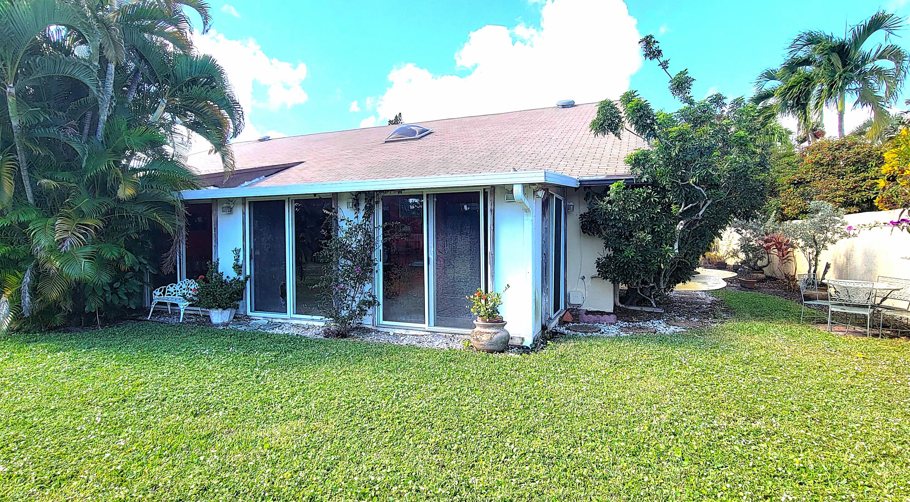 493 Southwest 28th Avenue Delray Beach, FL 33445 - Photo 2 of 48 a view of a house with a yard and lawn chairs with a fire pit