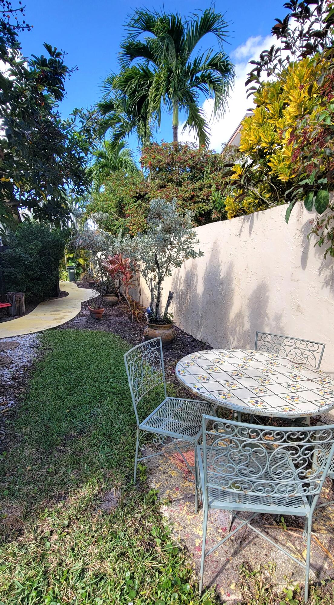 493 Southwest 28th Avenue Delray Beach, FL 33445 - Photo 39 of 48 a view of a backyard with table and chairs plants and swimming pool