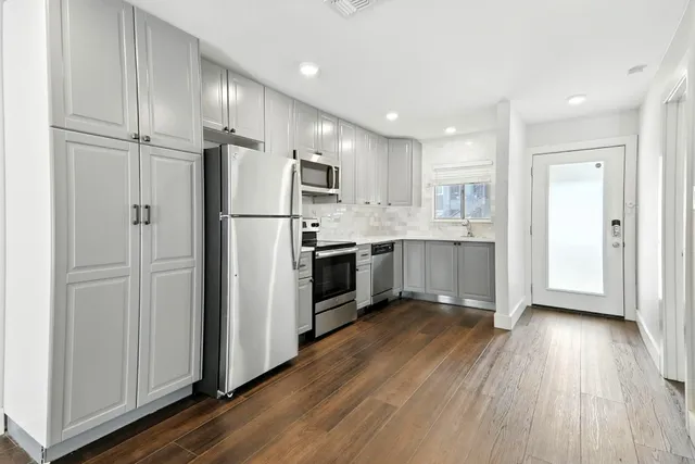 a kitchen with a refrigerator a sink and cabinets